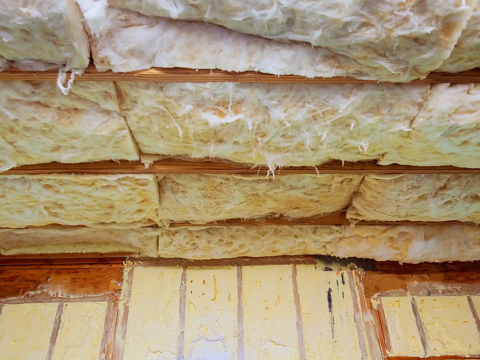 Ceiling batt insulation installed between joists over a rigid board assembly