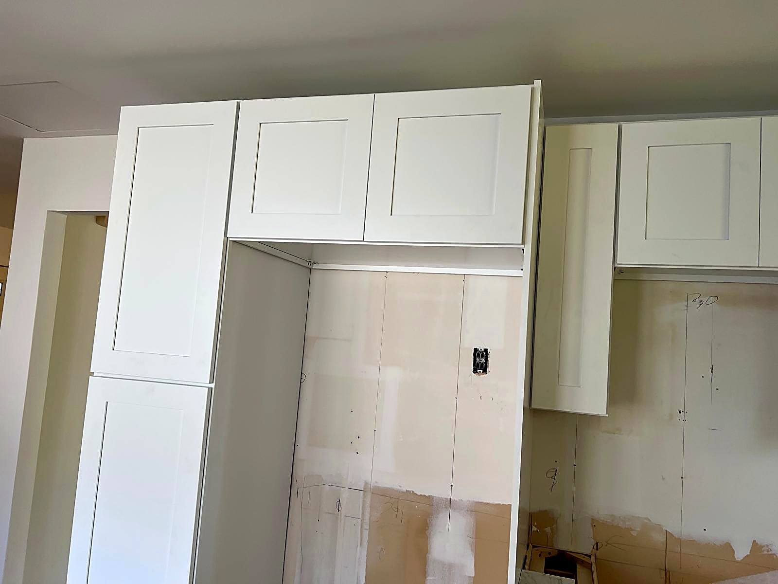 Tall pantry and bridge cabinetry with trim scribed to the ceiling