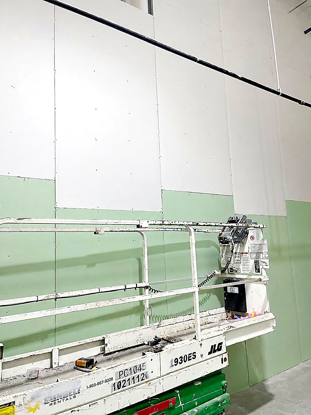 High commercial drywall wall installation from a scissor lift