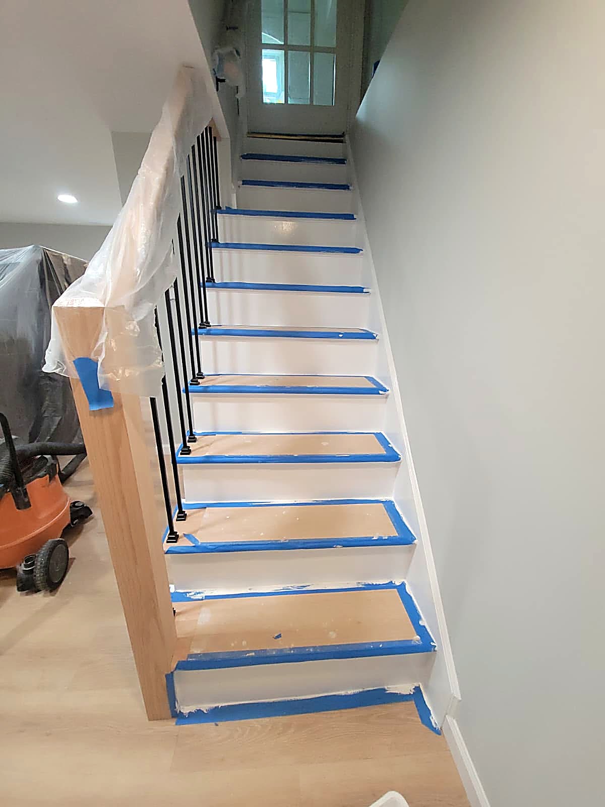 Completed stair carpentry with newel post, treads, and painted risers