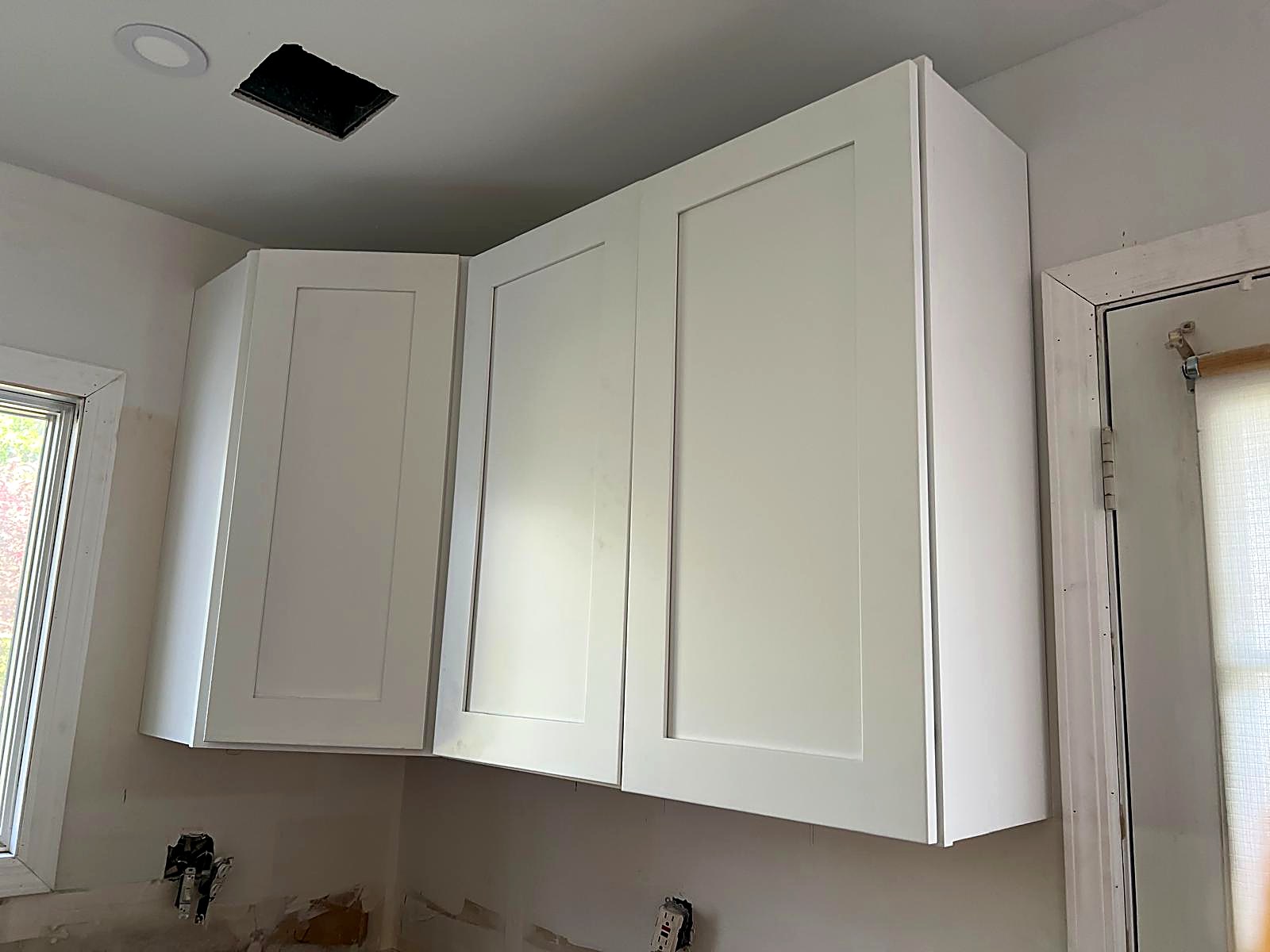 White upper cabinetry installed to the ceiling line with consistent reveals