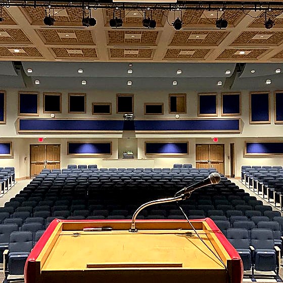 Auditorium wood coffered ceiling viewed from the stage with aligned downlights