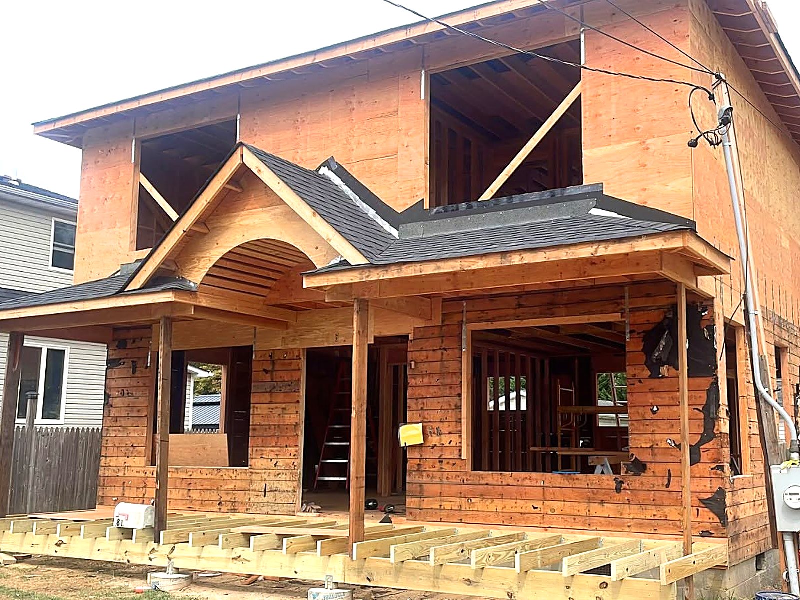 Residential addition framing with new porch, gables, and deck joists