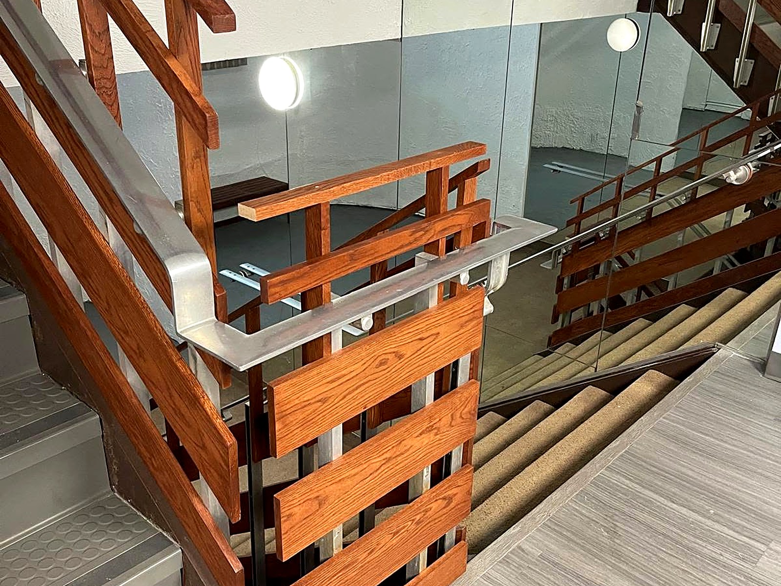 Renovated stairwell with refinished oak rail system and glass partition