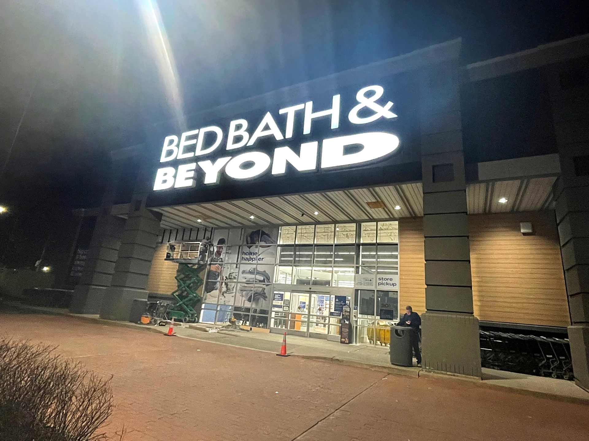 Bed Bath & Beyond storefront work underway at night with illuminated signage