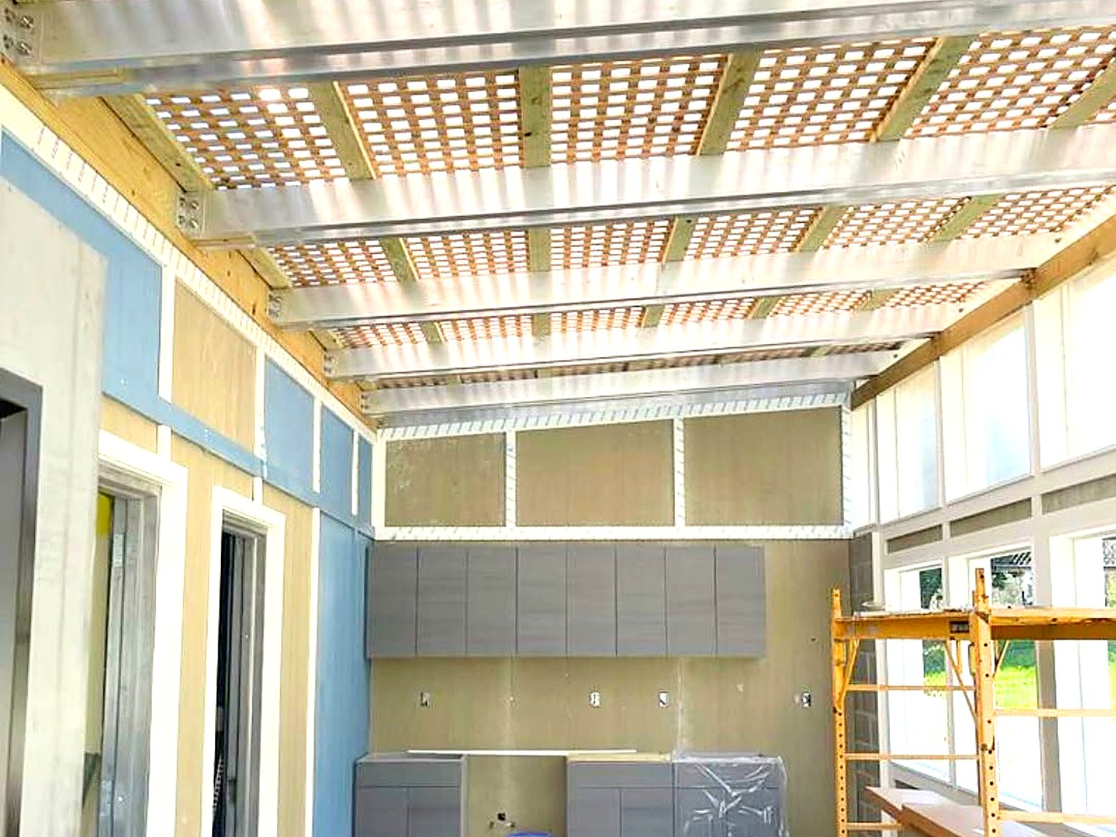Interior build-out with pergola-style roof framing and installed cabinetry