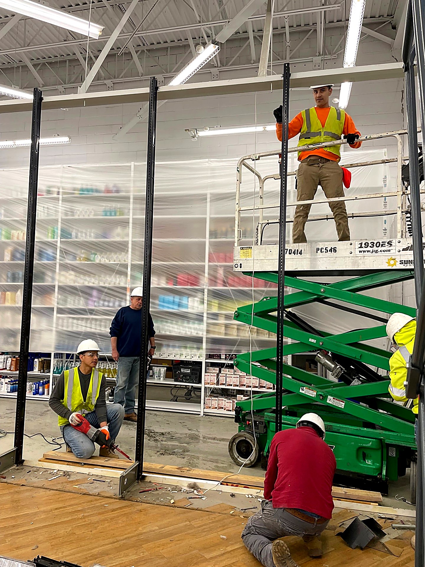 Carpentry crew installing steel wall track and studs during a retail fit-out