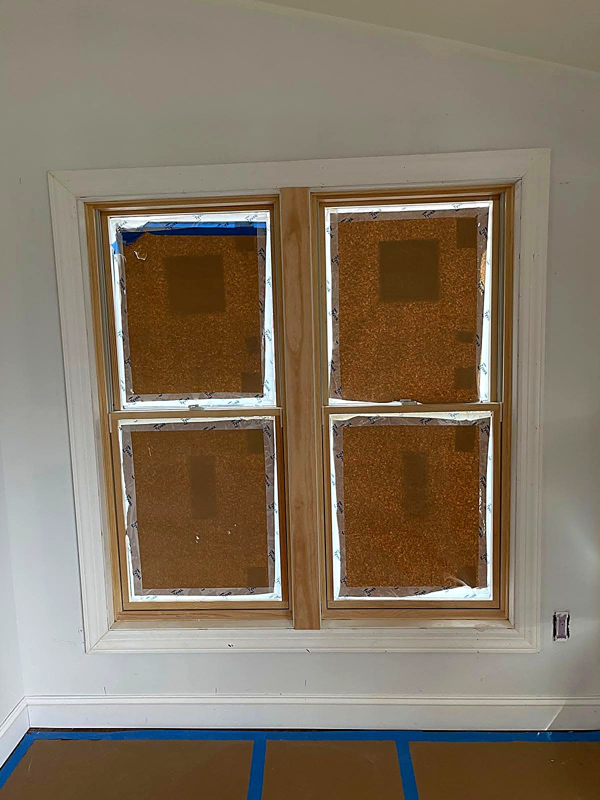New window casing and trim carpentry installed and masked for finishing