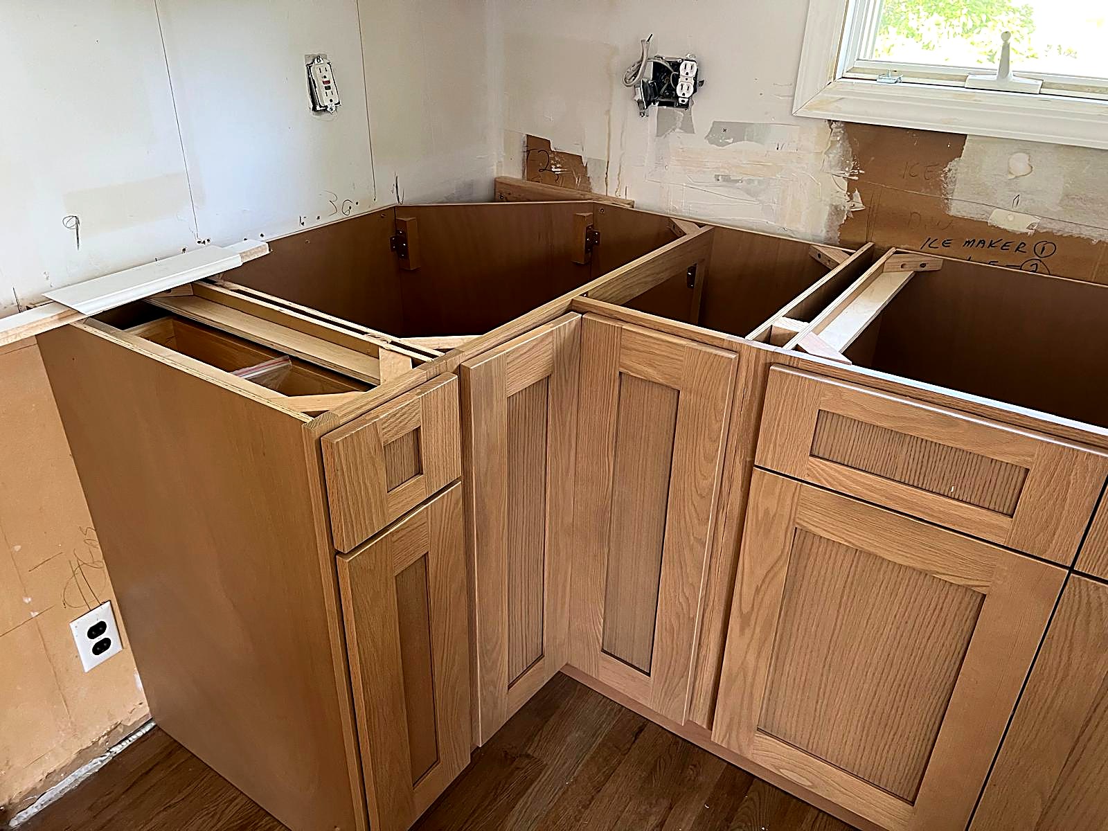 Corner base cabinet run and drawer boxes fitted with tight scribes and level tops