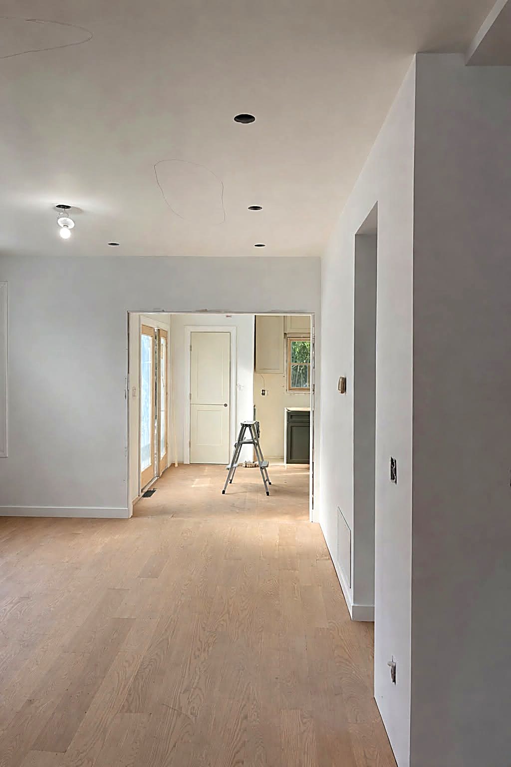 Finished and primed drywall walls and ceiling in an open renovated interior