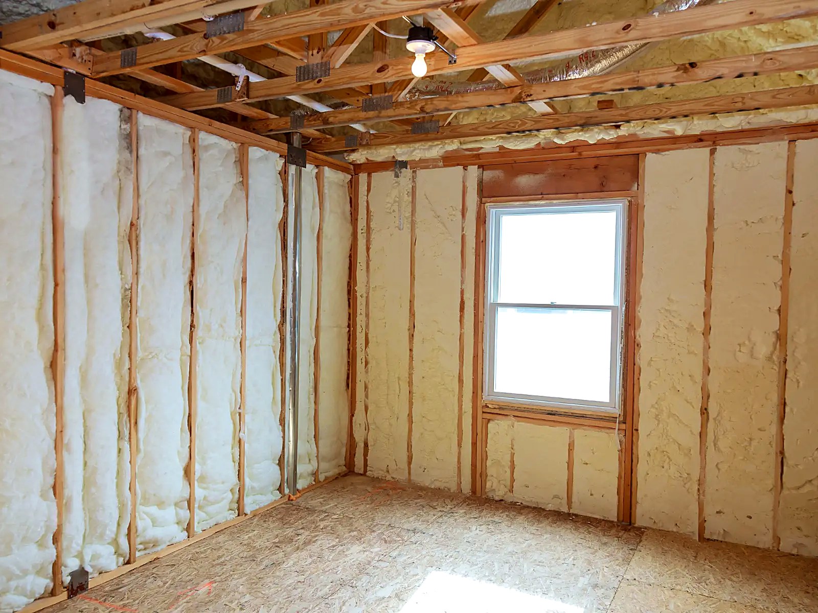 Fully insulated room with spray-applied insulation in walls and framed ceiling above
