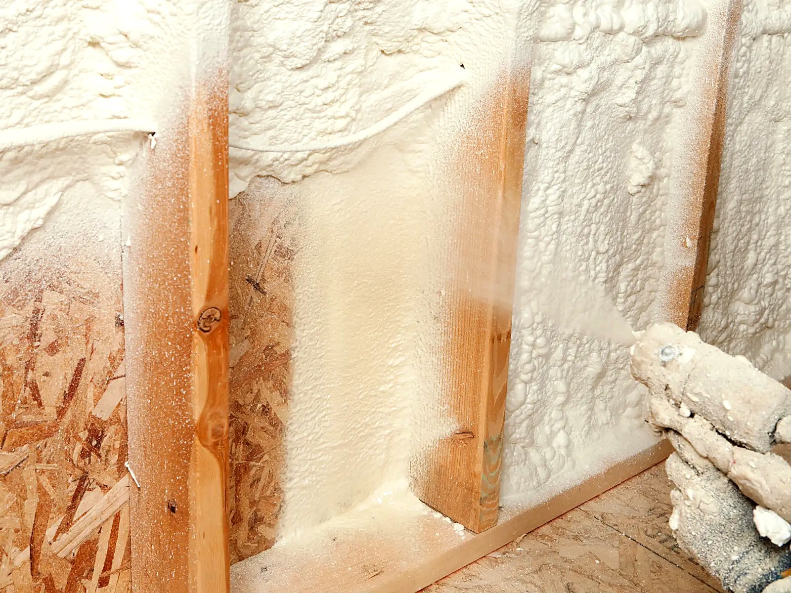 Closed-cell spray foam insulation and air sealing applied to a framed exterior wall