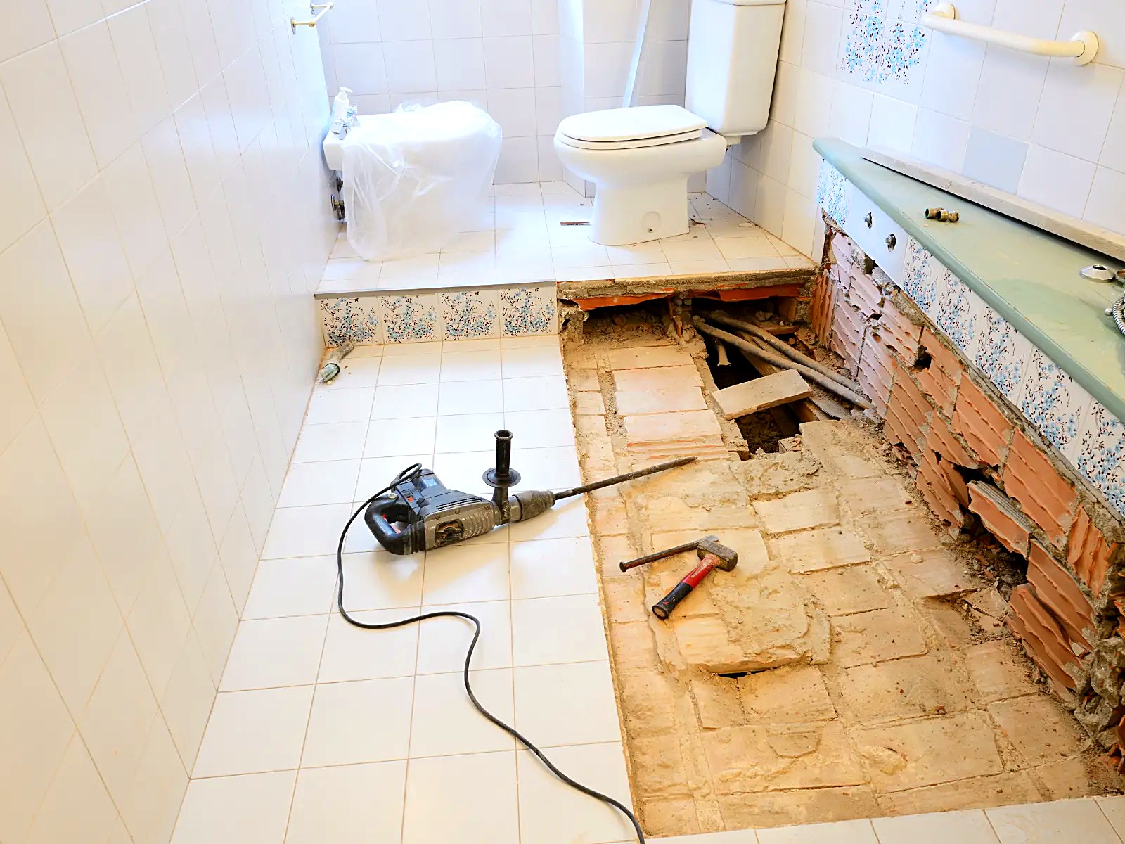 Bathroom demolition phase of a full remodel with floor opened for new plumbing