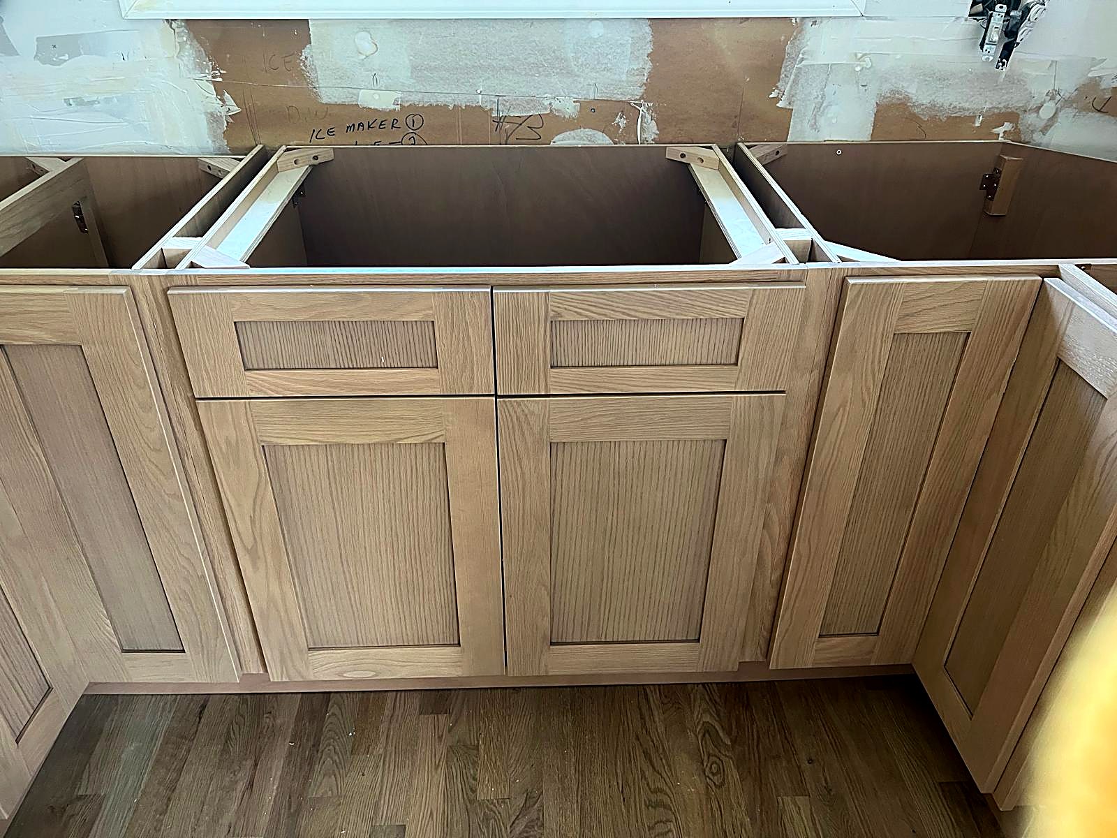 Oak sink base cabinetry with matched drawer fronts and countertop framing