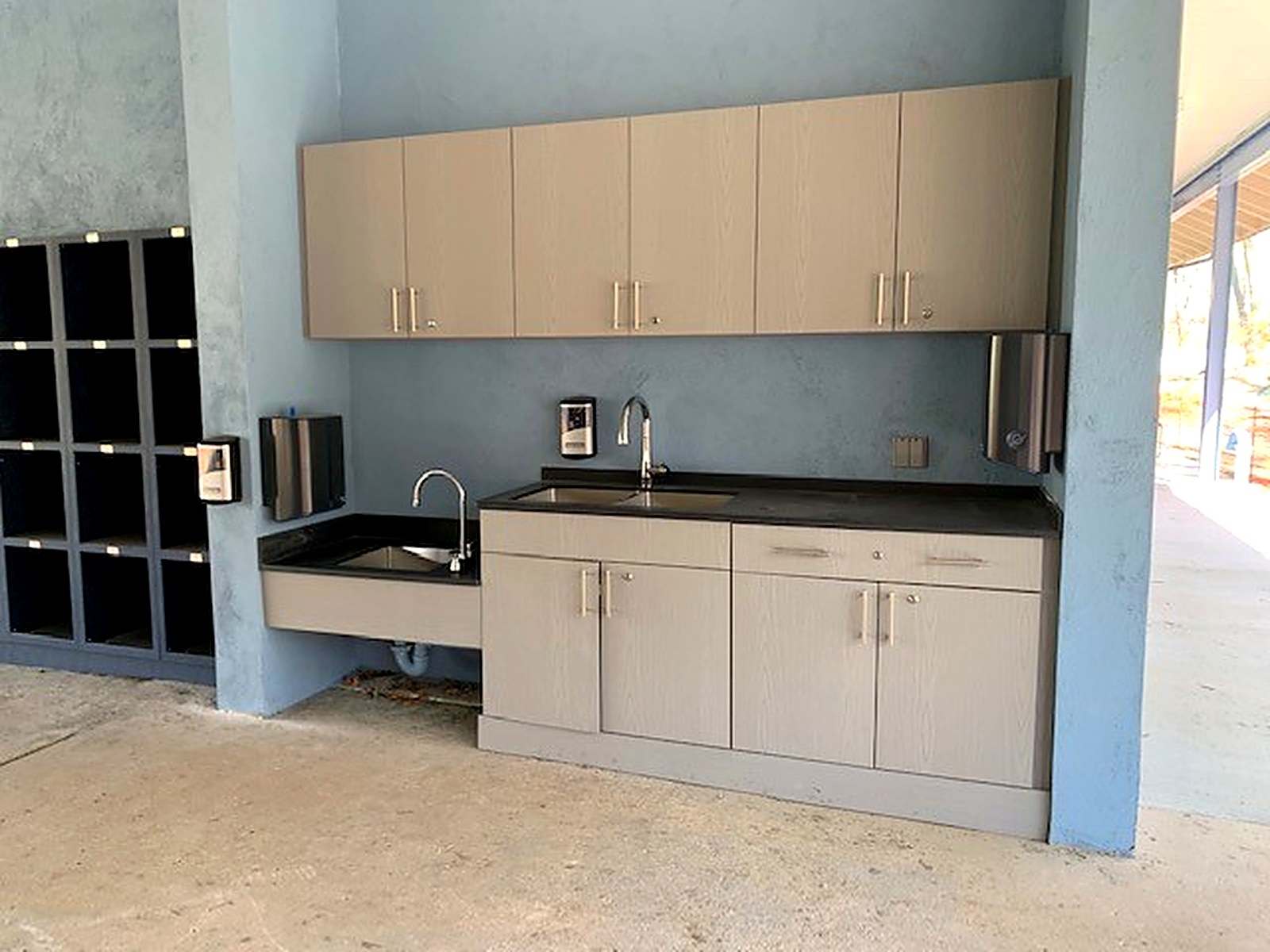 Commercial casework with upper and base cabinets at a stainless sink station