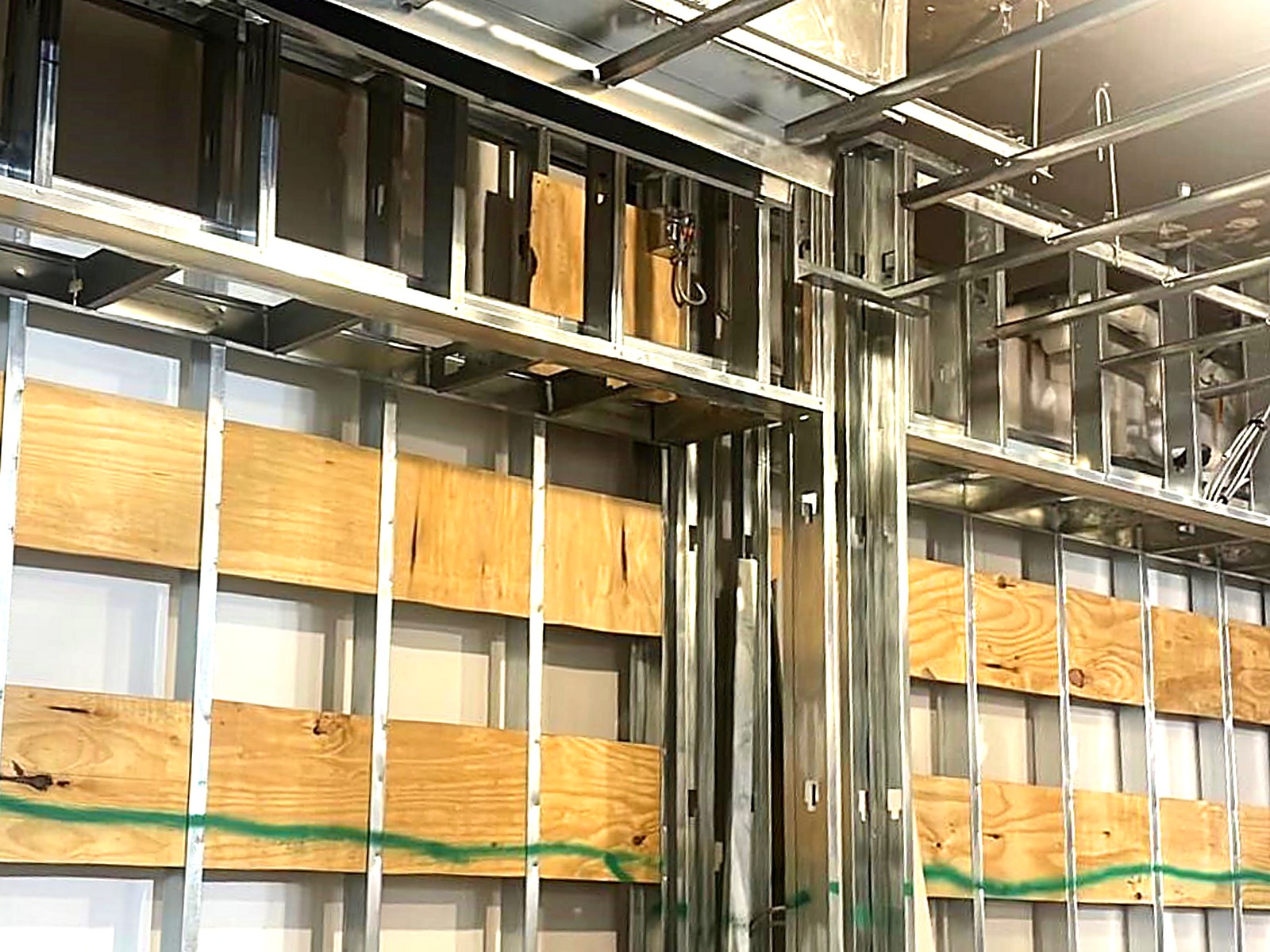 Stud framing with plywood backing and framed soffits at high ceiling level