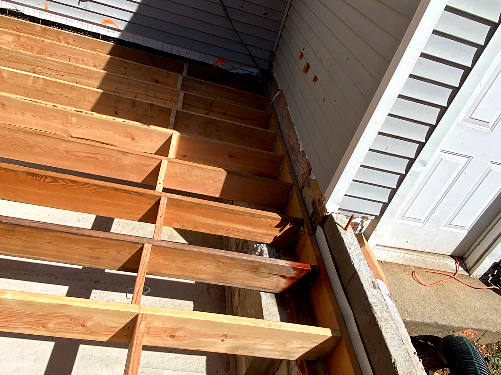 Deck ledger and beam connections detailed at the house wall with structural hardware