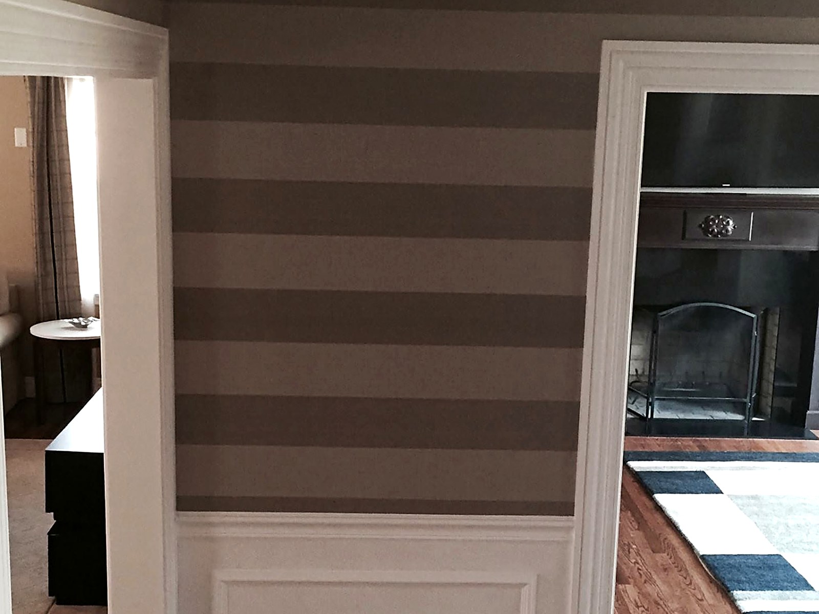Custom striped accent wall with painted wainscoting and trim