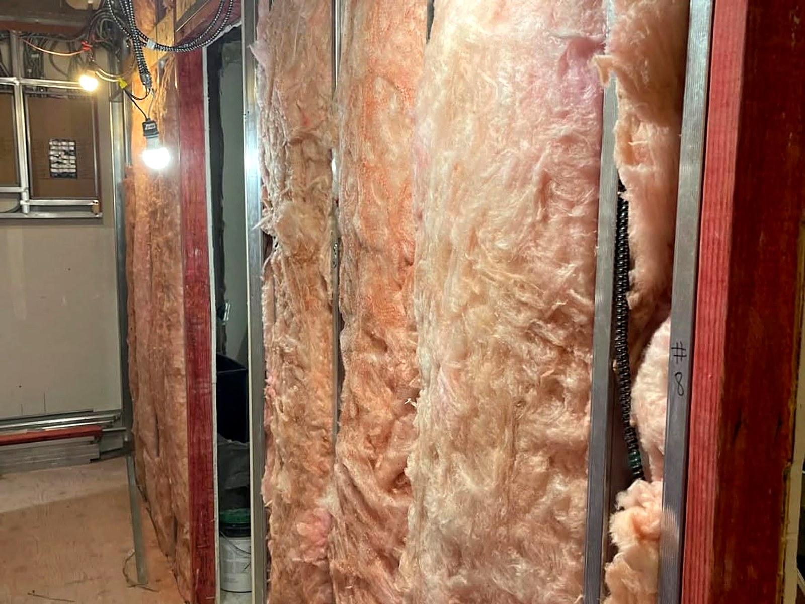 Acoustic batt insulation packed into demising walls on a commercial fit-out