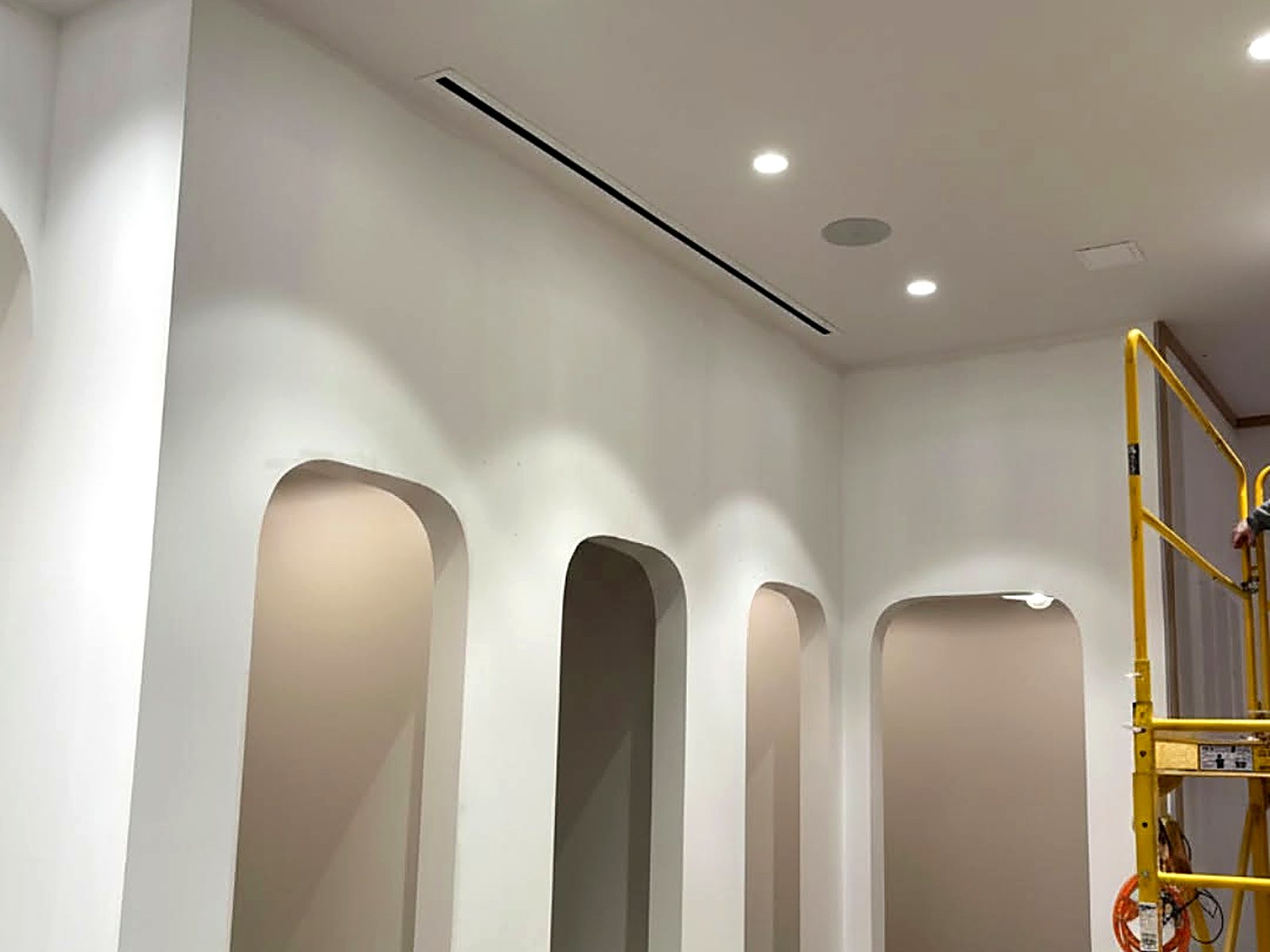 Completed drywall arches with smooth level-five finish and recessed lighting