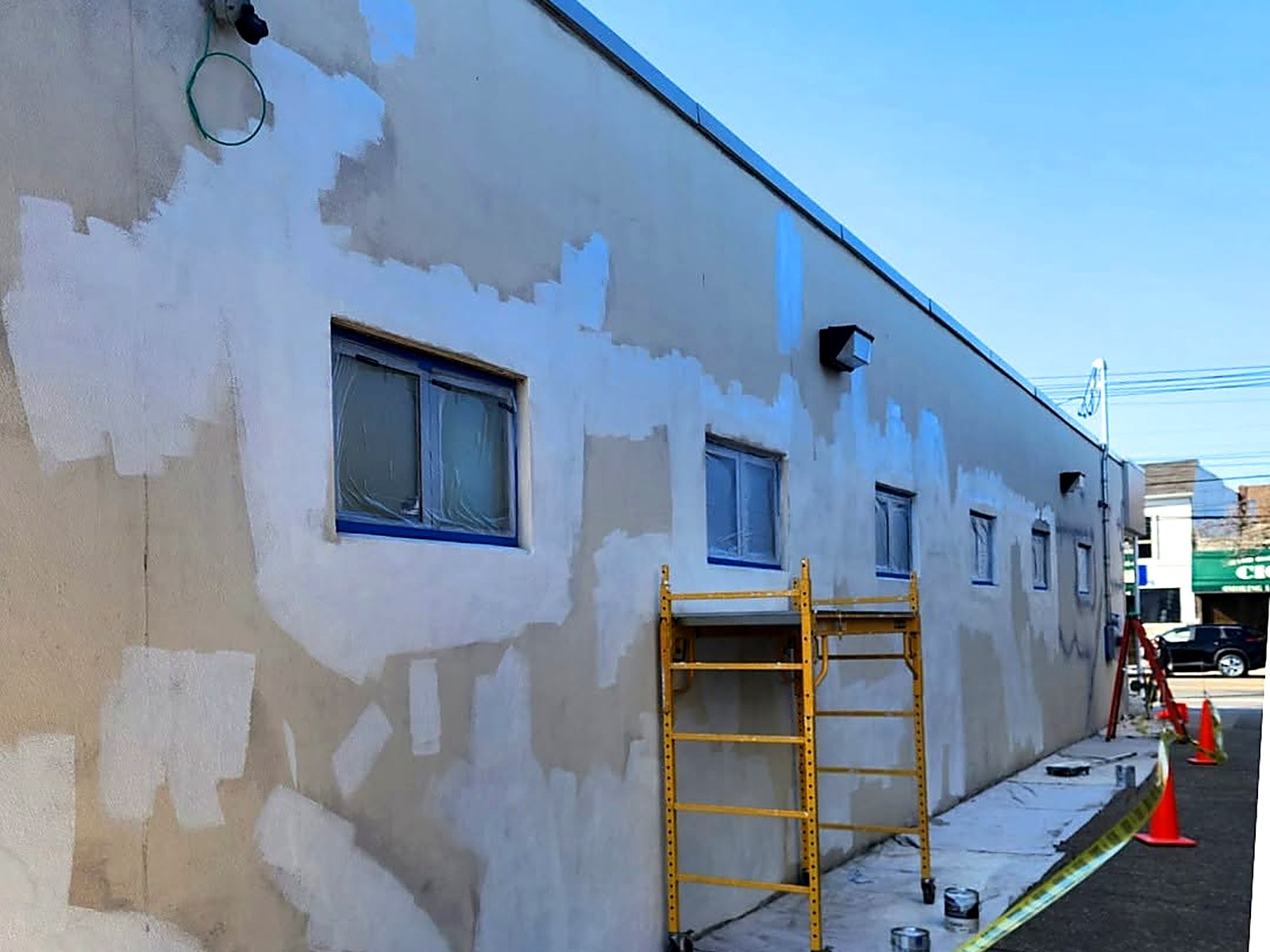 Commercial stucco facade prepped and primed for an exterior repaint