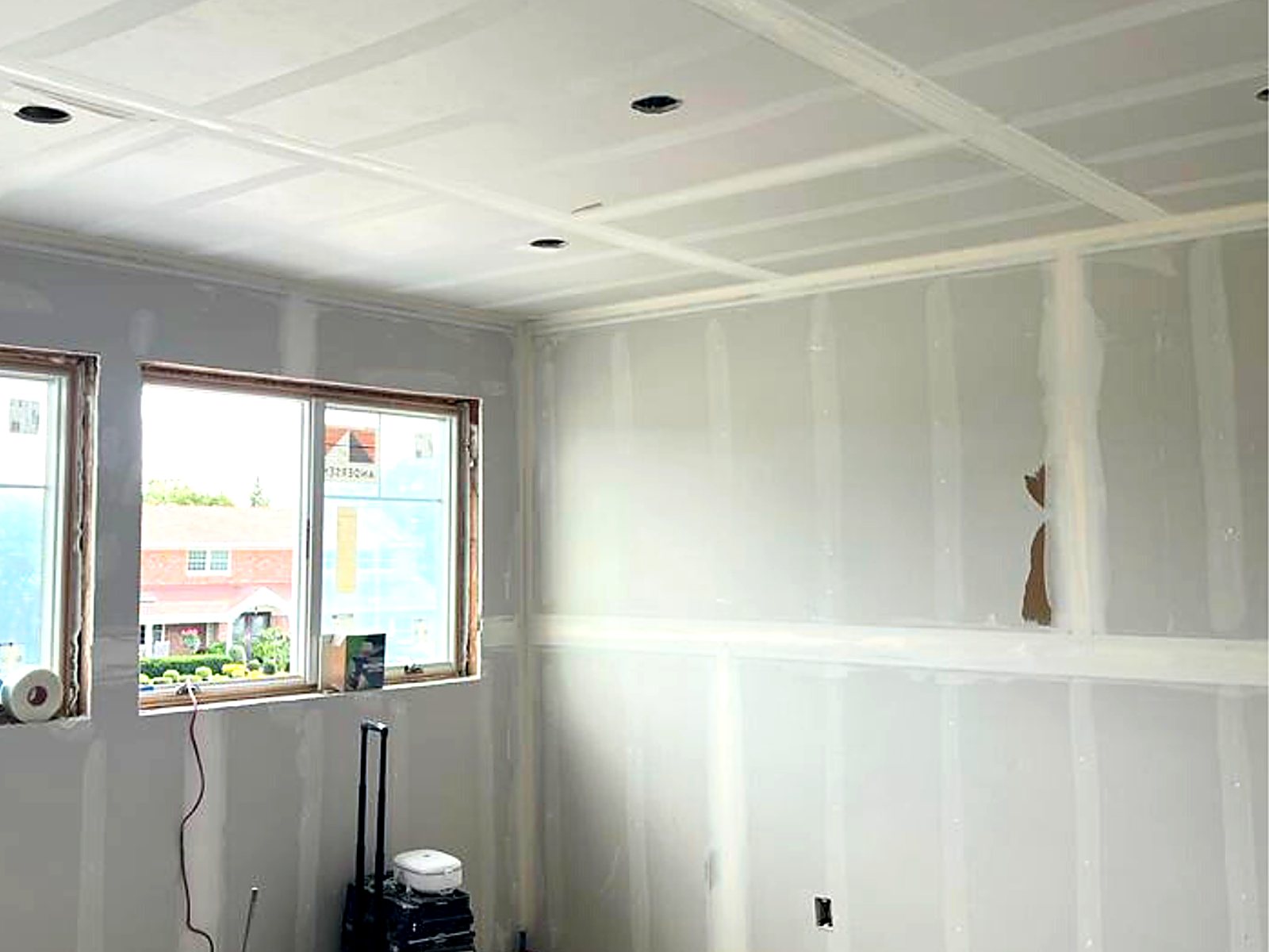 Taped and finished drywall walls and ceiling in a bright renovated room
