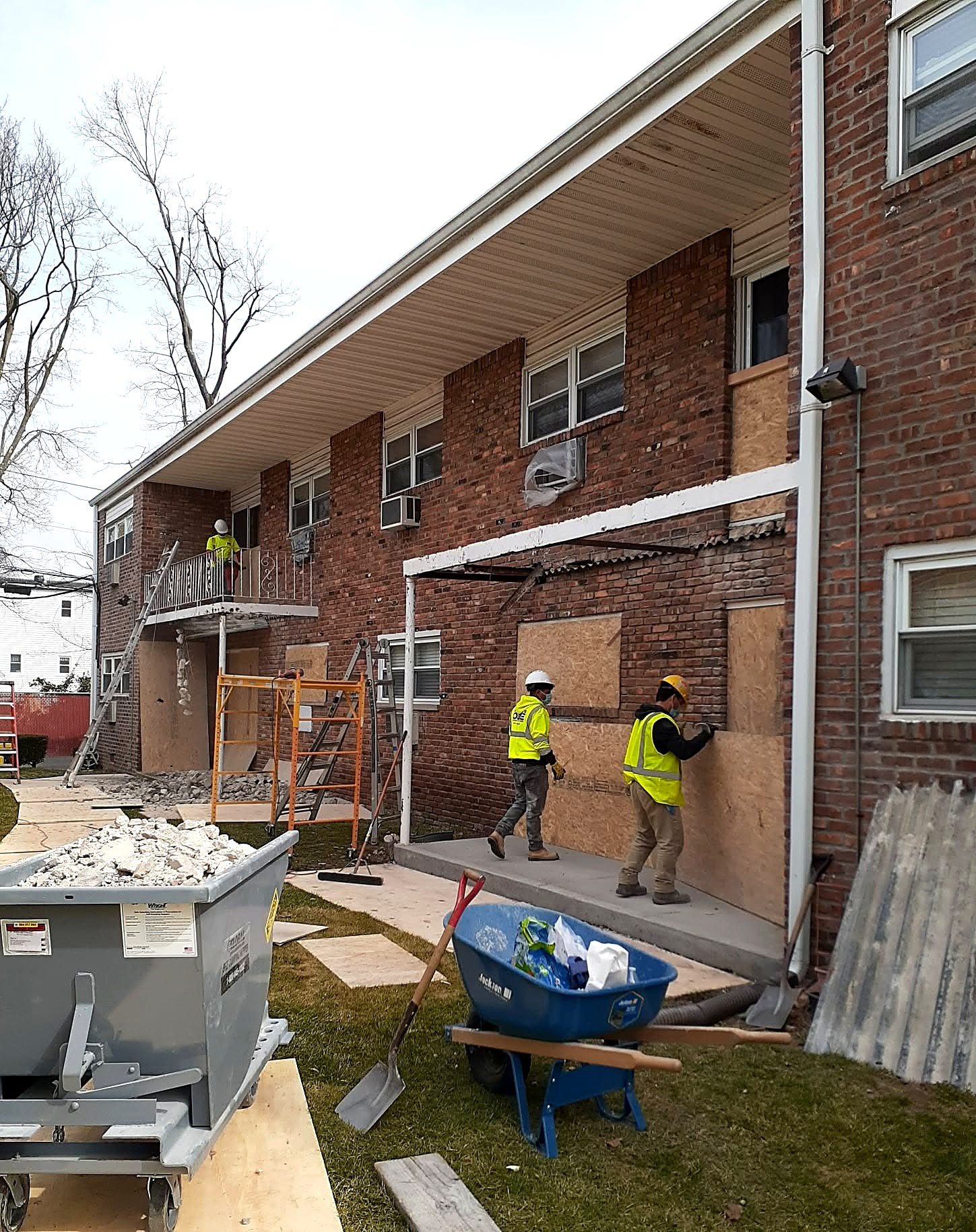Multifamily apartment building exterior restoration with crews on site