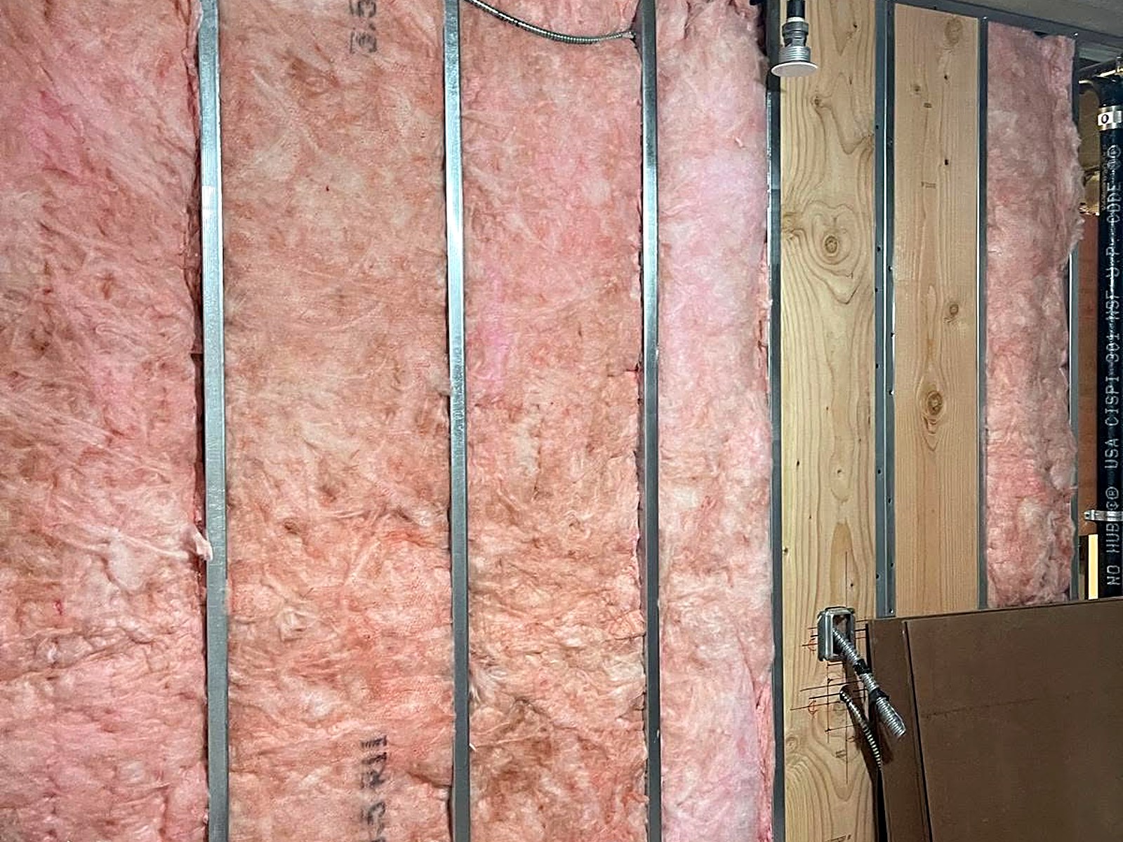 R-13 batt insulation installed in metal stud wall cavities ahead of drywall close-in