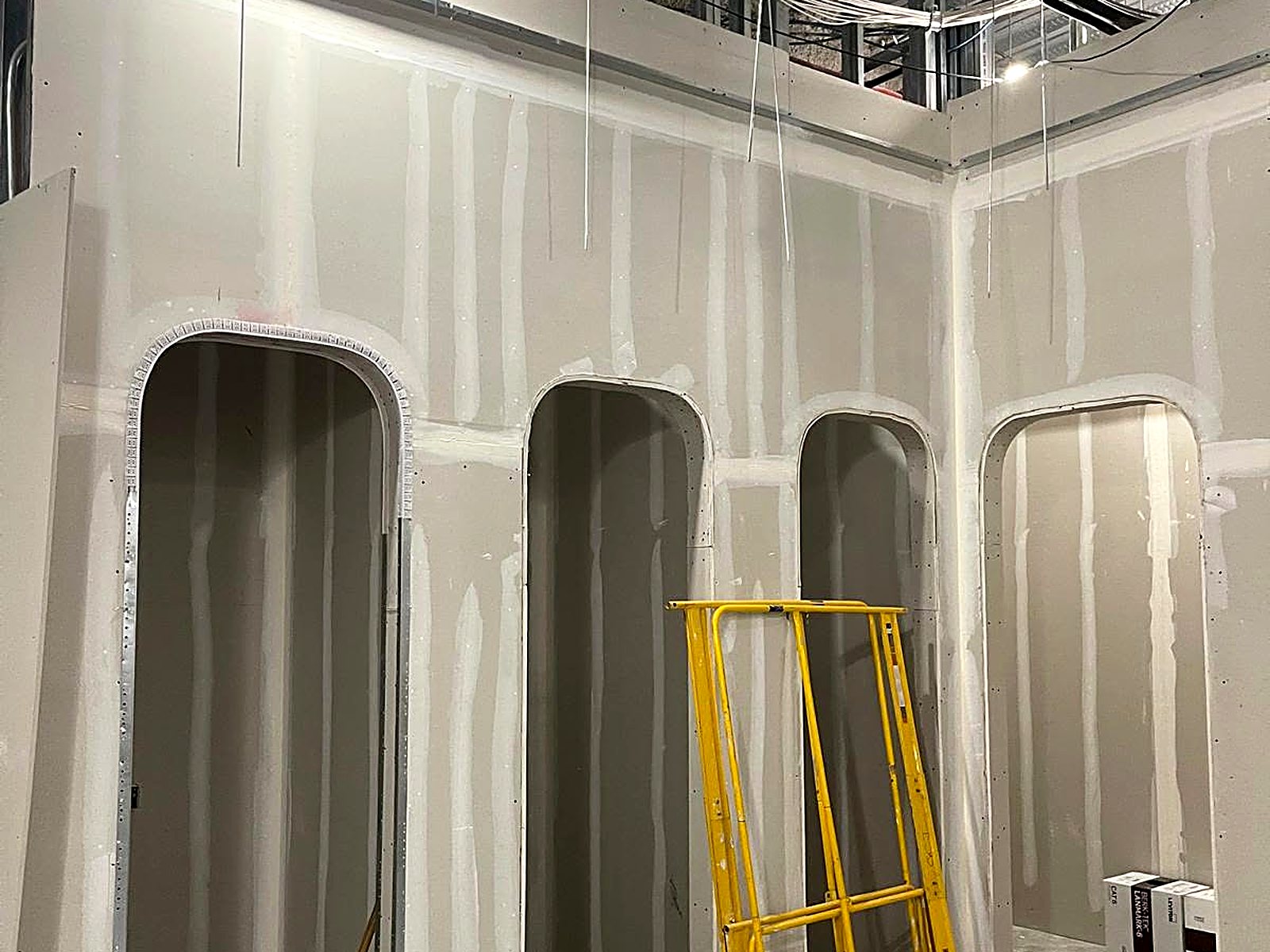 Curved drywall archways taped and ready for finish in a retail build-out